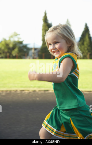 Girl Dressed as Cheerleader Running Stock Photo