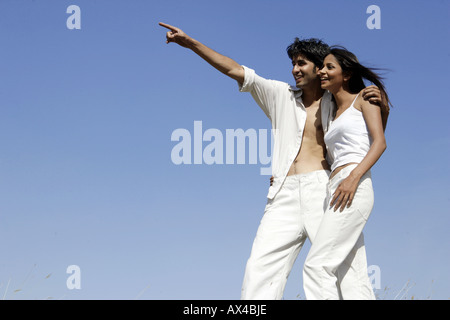 Young man standing with his girlfriend and pointing Stock Photo