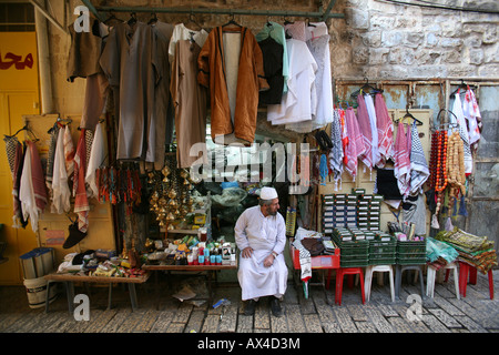 A vendors sits outside his stand at a market in the old city section of Jerusalem Stock Photo