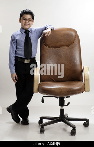 Portrait of a boy pretending like a chairman and smiling Stock Photo