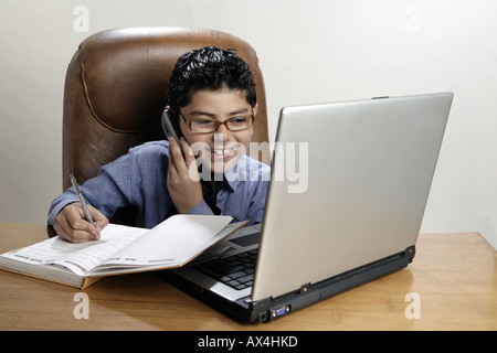 Boy working in office and pretending like a businessman Stock Photo