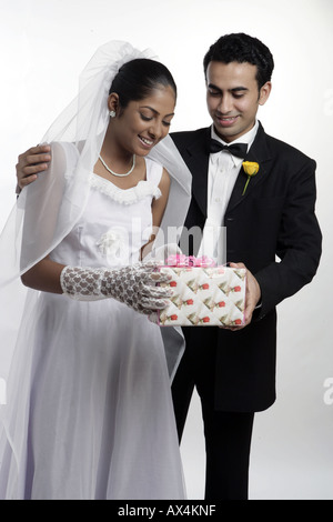 Groom giving gift to his bride and smiling Stock Photo