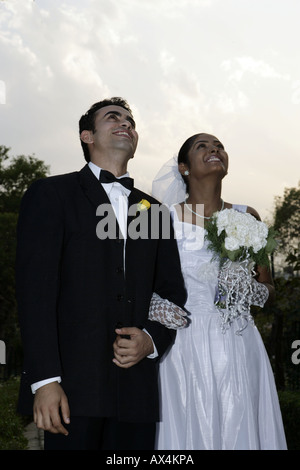 Low angle view of a married couple standing and smiling in a park Stock Photo