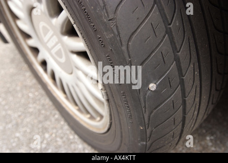 Automobile car tire tyre with sheet metal screw puncture causing a flat Stock Photo