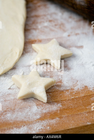 Rolled pastry with star shaped cookies before baking Stock Photo