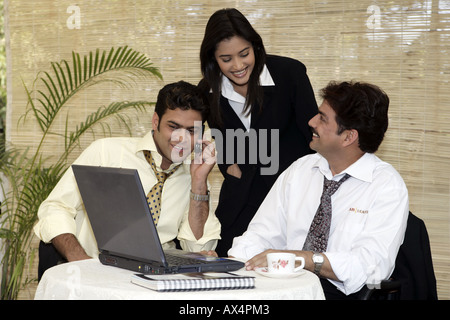 Three business people working in an office and smiling Stock Photo