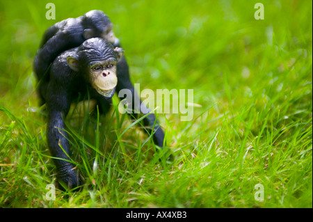 Childrens plastic chimpanzee toy on grass Stock Photo