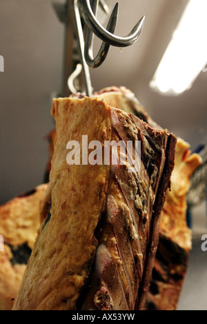 Organic beef carcasses / carcases hang on butcher's hooks in a farm freezer room Stock Photo