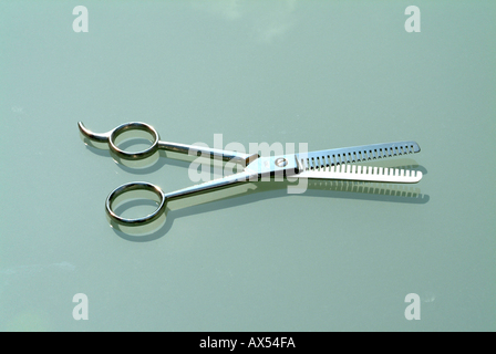 Old Barber Shop Thining Shears or Scissors on a Glass table Top Stock Photo