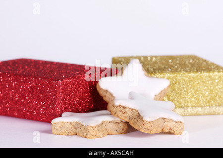 Cinnamon star cookies in front of christmas gifts Stock Photo