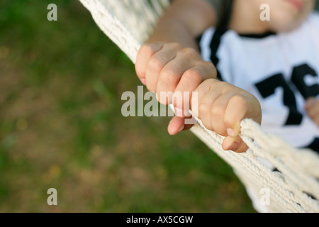 Father and son lying in hammock, focus on hands Stock Photo
