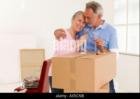 Mature couple holding champagne glasses, smiling Stock Photo