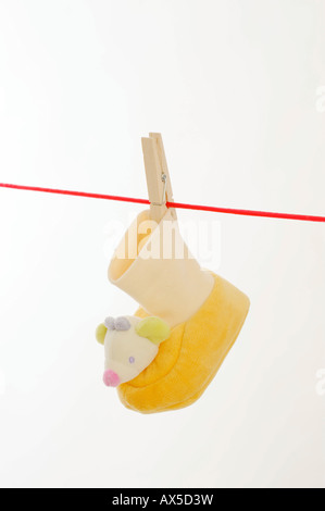 Baby shoe hanging from a clothesline Stock Photo