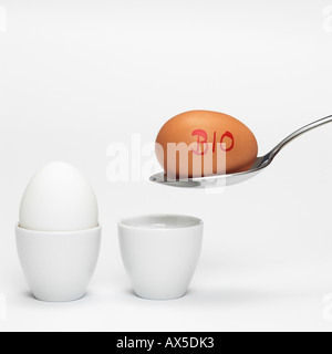 White and brown organic eggs in eggcup Stock Photo