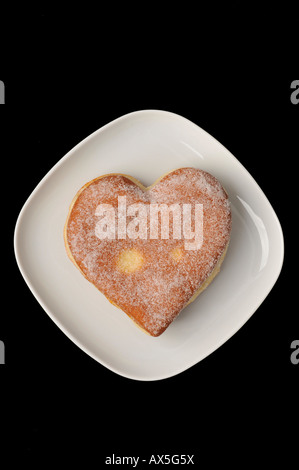 Heart-shaped Berliner (jelly-filled donut) on a plate Stock Photo