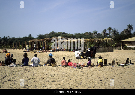 Banjul, The Gambia. Line of Gambians on the beach selling souvenirs and snacks to the tourists who have come to enjoy the sun. Stock Photo