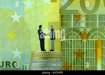 Two businessmen shaking hands, reaching a deal, 200-Euro note in the background Stock Photo