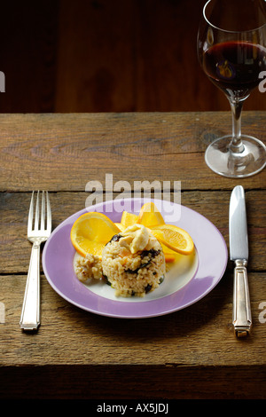 Risotto with dried fruit and candied walnuts. Arranged with slices of orange Stock Photo