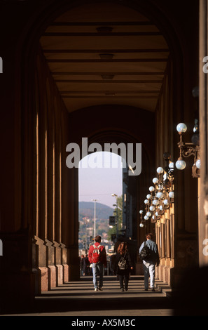 Budapest, Hungary. Three people with bags on their back walking under an arch. Stock Photo
