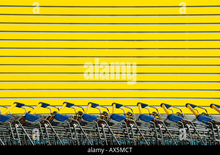 Stacked shopping carts in front of a yellow background, Eckental, Middle Franconia, Bavaria, Germany, Europe Stock Photo