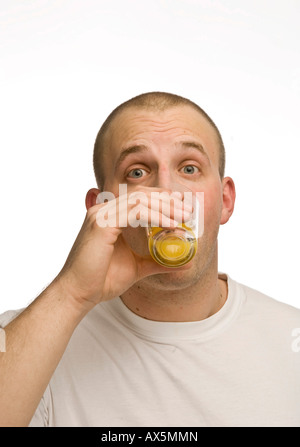 Young man drinking a glass of orange juice Stock Photo
