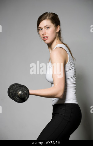 Young woman working out with weights, barbells Stock Photo