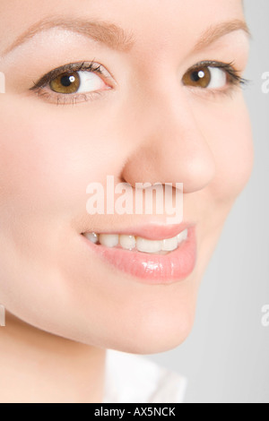 Close-up of a young woman's face looking into the camera, smiling Stock Photo