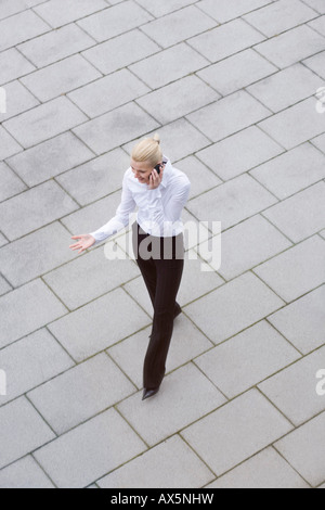 Businesswoman talking on phone as she walks Stock Photo