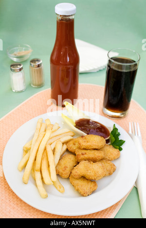 Chicken nuggets with barbecue sauce, chips and a glass of cola Stock Photo