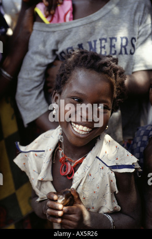 Zambia. Smiling young girl in a ragged dress with earrings. Stock Photo
