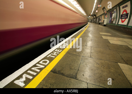 Mind the Gap - safety reminder and train coming through South Wimbledon underground station, London, England, UK, Europe Stock Photo