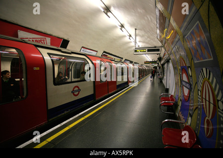 Tube logo, colorful tiles and train arriving at London Arch underground station, London, England, UK, Europe Stock Photo