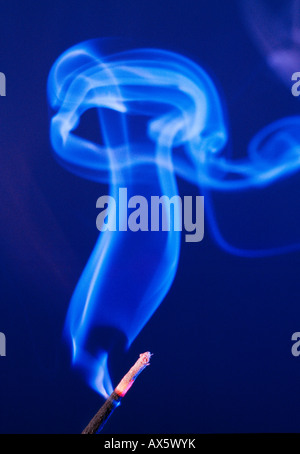 Smoke rising from an incense stick Stock Photo