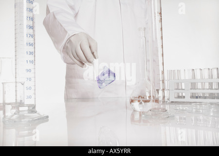 Chemist checking liquid in flask in a lab Stock Photo