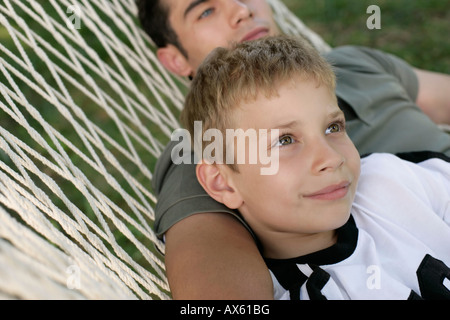 Father and son lying together in a hammock Stock Photo