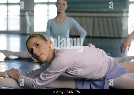 Female ballet dancers doing stretching exercises on the floor Stock Photo