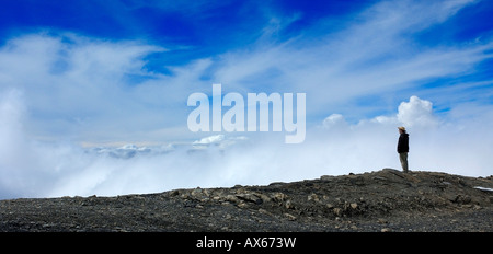 A man admires the view from the top of a mountain. Stock Photo