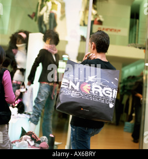 Young man with carrier bag and Energii logo window shopping in the Via del Corso, Rome  KATHY DEWITT Stock Photo