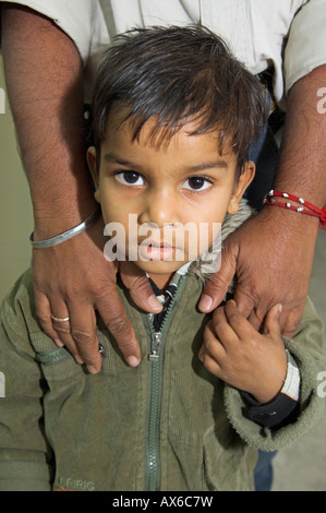 Portrait of small Omani boy with fathers hands on shoulders in Muscat Sultanate of Oman Stock Photo