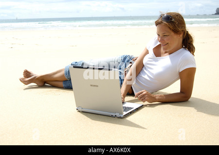 Close-up of woman using laptop on the beach Stock Photo