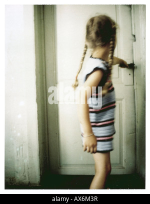 Side profile of girl pulling door Stock Photo