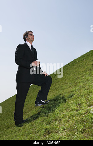 Businessman on steep hill Stock Photo