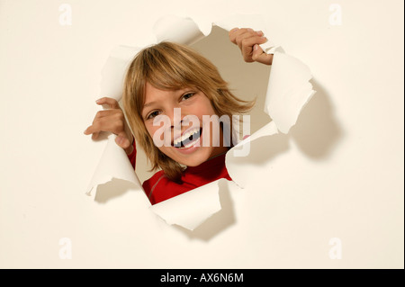 Portrait of boy looking through paper hole Stock Photo