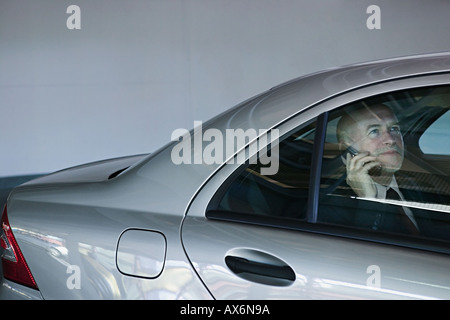 Businessman in a car using mobile phone Stock Photo