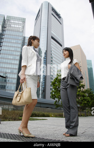 Two women having a conversation in a commercial area Stock Photo