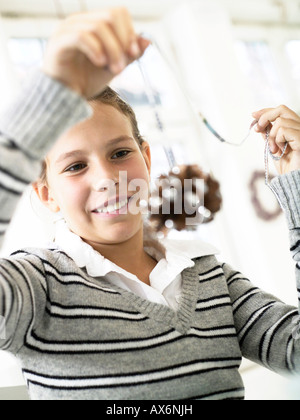 Close-up of teenage girl looking at pine cone and smiling Stock Photo