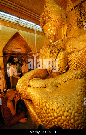 Small group of buddhist praying monks seen from behind in Lumbini