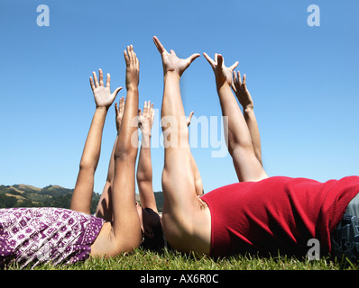 Friends lying down and raising arms Stock Photo