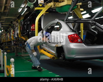 Factory workers producing the hybrid Toyota Prius cars work on the assembly line at the Toyota City Stock Photo