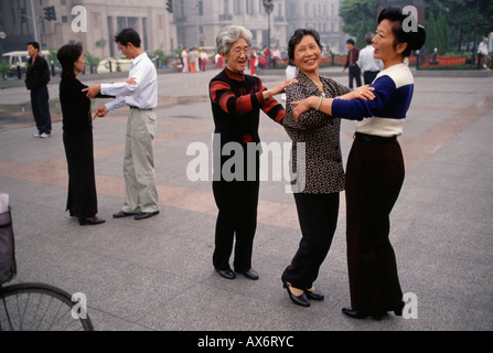 Three women practice dancing the waltz together on the Bund in Shanghai Stock Photo
